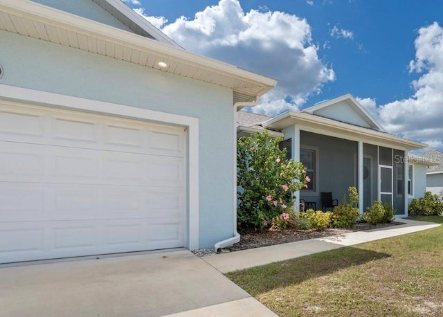 2229 Wakefield St, Port Charlotte, FL 33948 - view of property exterior featuring stucco siding, a garage, concrete driveway, and a sunroom
