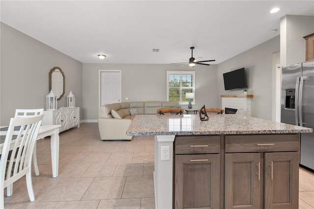 2229 Wakefield St, Port Charlotte, FL 33948 - kitchen with stainless steel fridge with ice dispenser, open floor plan, a ceiling fan, light tile patterned floors, and light stone countertops