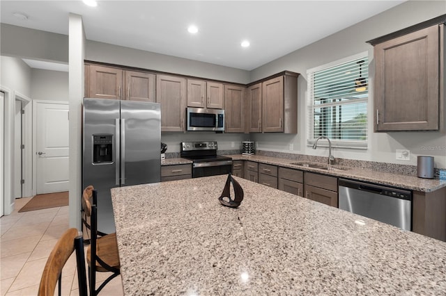 2229 Wakefield St, Port Charlotte, FL 33948 - kitchen featuring appliances with stainless steel finishes, a sink, light stone counters, recessed lighting, and light tile patterned flooring