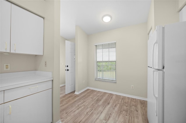 175 Kings Hwy Unit B21522, Punta Gorda, FL 33983 - kitchen with freestanding refrigerator, light wood-style flooring, white cabinets, light countertops, and baseboards
