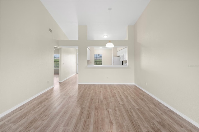 175 Kings Hwy Unit B21522, Punta Gorda, FL 33983 - unfurnished living room featuring a high ceiling, visible vents, light wood-type flooring, and baseboards
