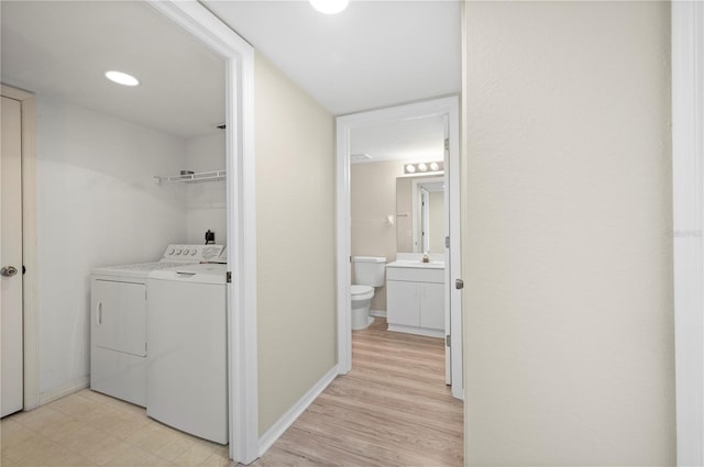 175 Kings Hwy Unit B21522, Punta Gorda, FL 33983 - laundry room featuring baseboards, a sink, laundry area, light wood-style flooring, and washing machine and dryer