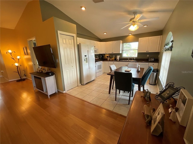 1536 Willow Dl, Sebring, FL 33872 - kitchen with white appliances, white cabinets, a sink, dark countertops, and lofted ceiling