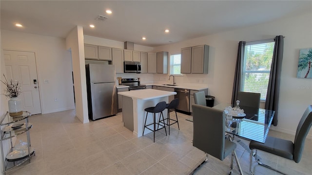 26456 View Dr, Punta Gorda, FL 33983 - kitchen with appliances with stainless steel finishes, gray cabinetry, a kitchen breakfast bar, a kitchen island, and recessed lighting