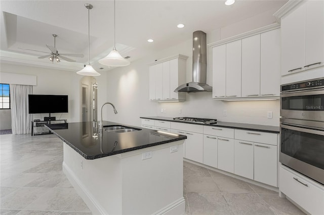 kitchen featuring recessed lighting, wall chimney exhaust hood, a sink, and dark countertops