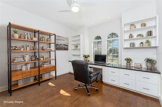 office space with built in features, baseboards, a ceiling fan, and dark wood finished floors