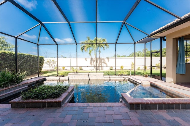 view of swimming pool with a patio area, a pool with connected hot tub, fence, and glass enclosure