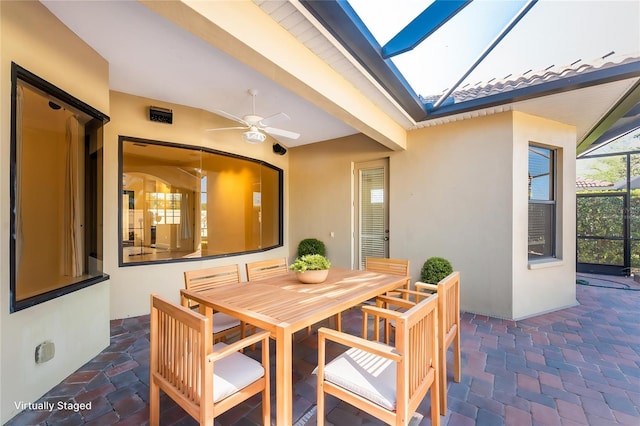 view of patio / terrace featuring a lanai, outdoor dining space, and ceiling fan