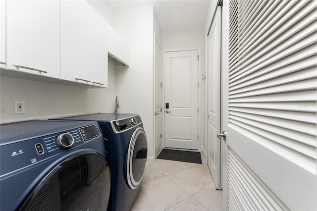clothes washing area with light tile patterned flooring, cabinet space, and washer and clothes dryer