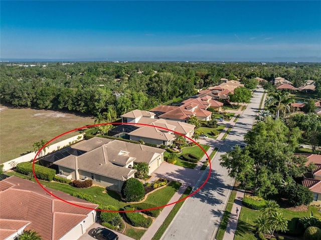 drone / aerial view with a wooded view and a residential view