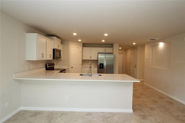 kitchen with a sink, light countertops, recessed lighting, and stainless steel appliances