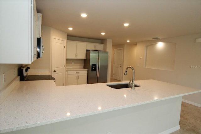 kitchen featuring a sink, recessed lighting, white cabinetry, light stone countertops, and stainless steel appliances