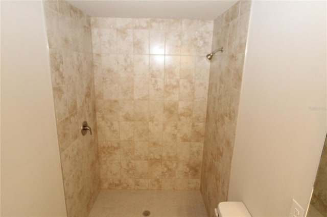 bathroom with tiled shower and toilet