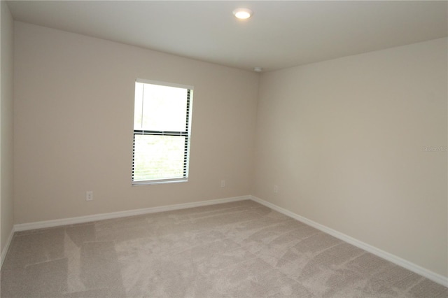 spare room with light carpet, baseboards, and recessed lighting