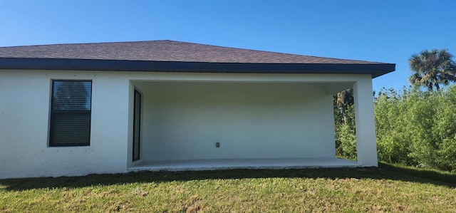 view of side of home featuring a lawn and stucco siding
