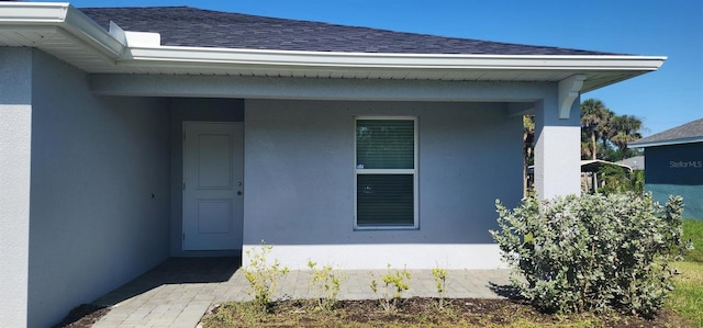 4071 Conestoga St, Port Charlotte, FL 33948 - view of exterior entry with roof with shingles and stucco siding