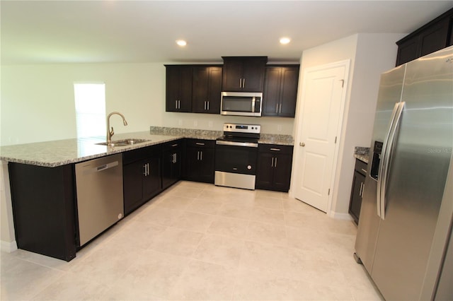 4071 Conestoga St, Port Charlotte, FL 33948 - kitchen featuring a peninsula, light stone counters, light tile patterned flooring, a sink, and stainless steel appliances