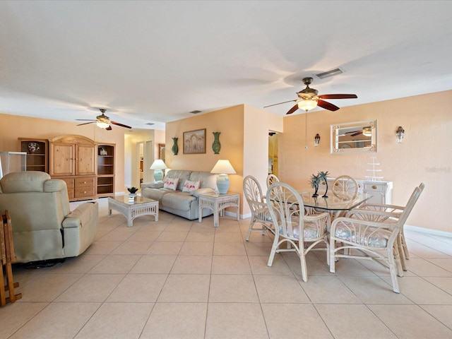 dining room with light tile patterned floors, baseboards, a ceiling fan, and visible vents