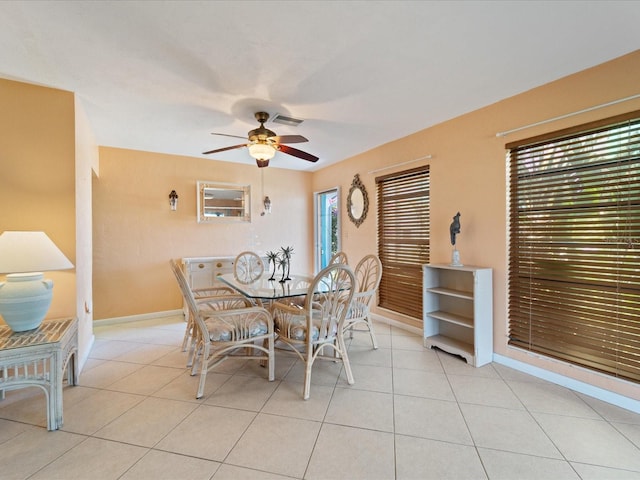 dining room featuring light tile patterned flooring, ceiling fan, baseboards, and visible vents