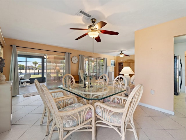 dining area with visible vents, baseboards, a ceiling fan, and light tile patterned flooring