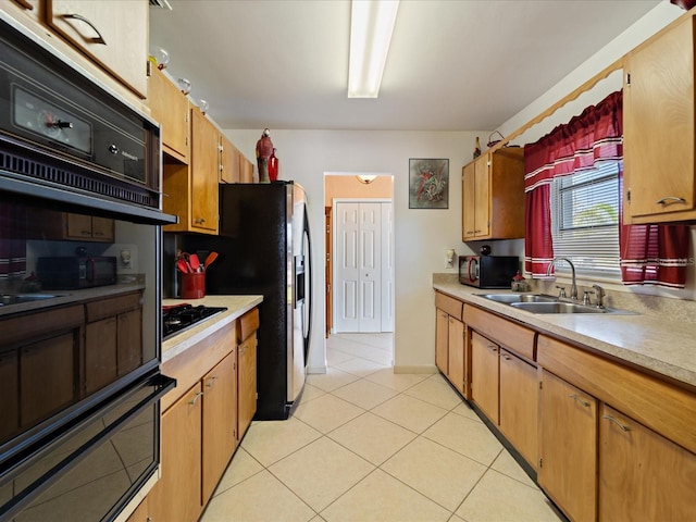 kitchen featuring a sink, light countertops, black appliances, and light tile patterned flooring