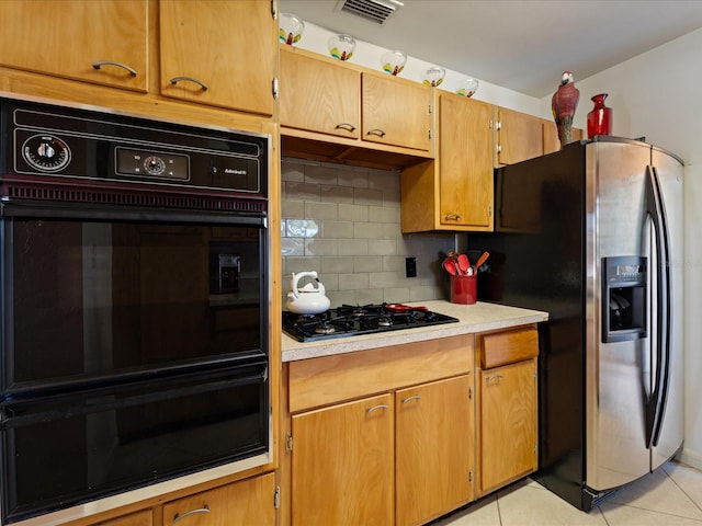 kitchen featuring light tile patterned floors, light countertops, visible vents, decorative backsplash, and black appliances