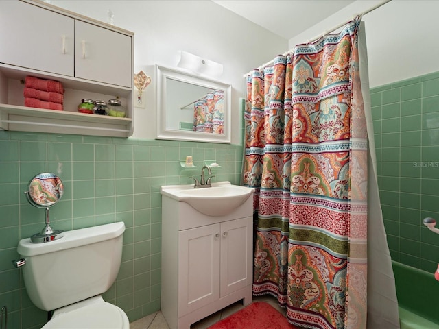 bathroom featuring toilet, vanity, and tile walls