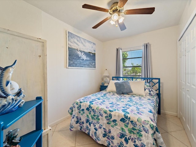 bedroom featuring a closet, baseboards, a ceiling fan, and light tile patterned flooring
