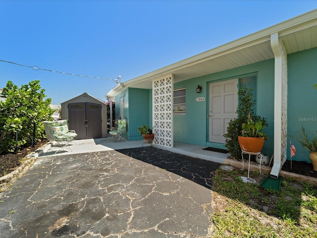 view of exterior entry featuring a patio and stucco siding