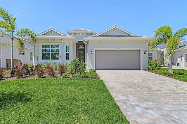 14413 Heritage Landing Blvd, Punta Gorda, FL 33955 - view of front facade featuring decorative driveway, a garage, a front lawn, and stucco siding