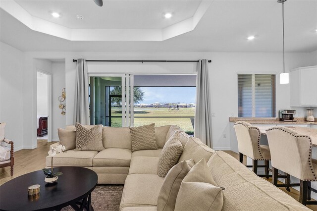 14413 Heritage Landing Blvd, Punta Gorda, FL 33955 - living area featuring a tray ceiling, light wood finished floors, baseboards, and recessed lighting