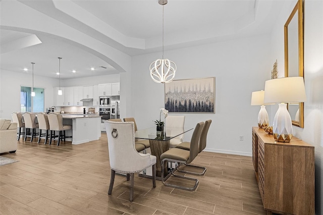 14413 Heritage Landing Blvd, Punta Gorda, FL 33955 - dining area featuring arched walkways, a raised ceiling, light wood-style flooring, a chandelier, and recessed lighting