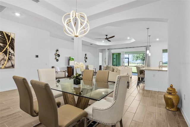 14413 Heritage Landing Blvd, Punta Gorda, FL 33955 - dining room with a raised ceiling, a ceiling fan, a chandelier, recessed lighting, and light wood finished floors