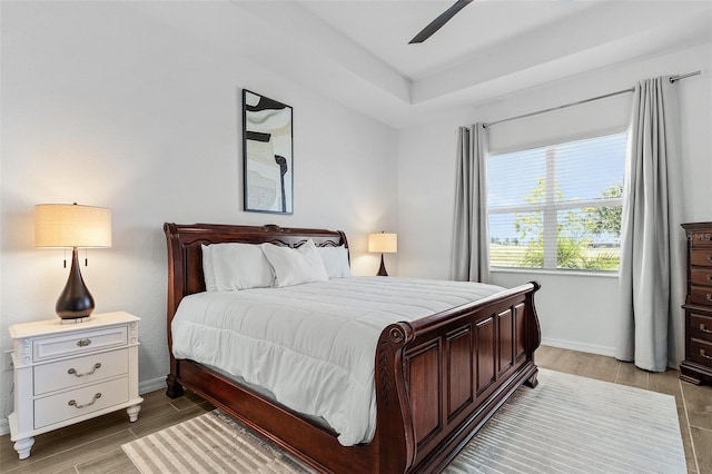 14413 Heritage Landing Blvd, Punta Gorda, FL 33955 - bedroom featuring baseboards, light wood-style flooring, a tray ceiling, and ceiling fan