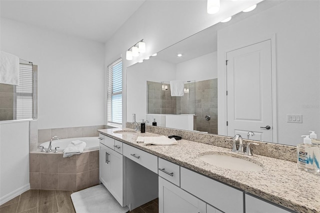 14413 Heritage Landing Blvd, Punta Gorda, FL 33955 - bathroom with double vanity, wood finished floors, a garden tub, and a walk in shower