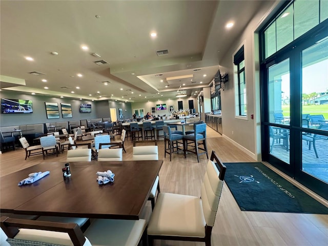 14413 Heritage Landing Blvd, Punta Gorda, FL 33955 - dining room with light wood-style floors, recessed lighting, a tray ceiling, and baseboards
