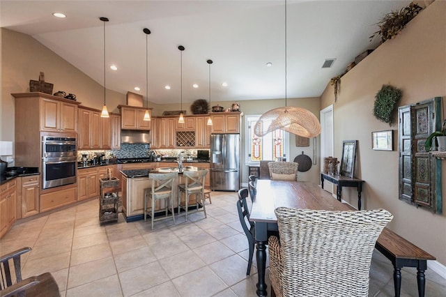3712 Balboa Ct, Punta Gorda, FL 33983 - kitchen with stainless steel appliances, decorative backsplash, a kitchen island with sink, under cabinet range hood, and light tile patterned flooring