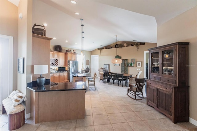 3712 Balboa Ct, Punta Gorda, FL 33983 - kitchen featuring stainless steel fridge, vaulted ceiling, light tile patterned flooring, hanging light fixtures, and a peninsula
