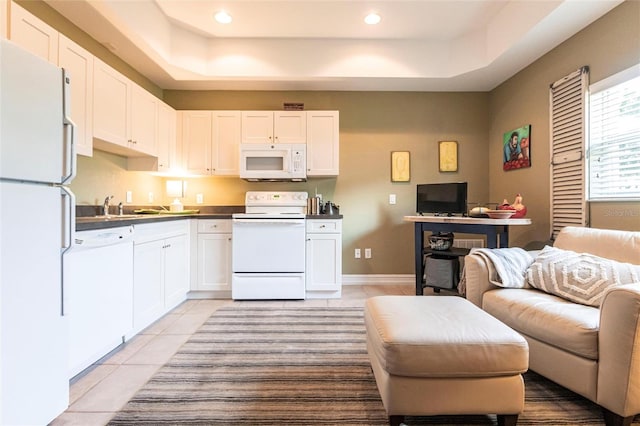 3712 Balboa Ct, Punta Gorda, FL 33983 - kitchen with white appliances, open floor plan, light tile patterned floors, a tray ceiling, and white cabinetry