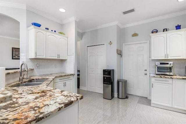 16450 Bauers Ave, Port Charlotte, FL 33954 - kitchen featuring a sink, visible vents, tasteful backsplash, and light stone countertops