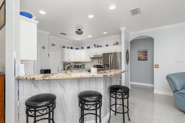 16450 Bauers Ave, Port Charlotte, FL 33954 - kitchen featuring a peninsula, under cabinet range hood, light stone countertops, visible vents, and stainless steel appliances