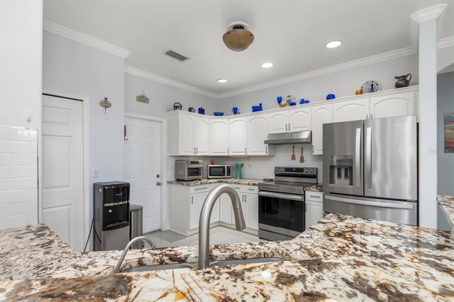 16450 Bauers Ave, Port Charlotte, FL 33954 - kitchen featuring under cabinet range hood, light stone counters, white cabinetry, and stainless steel appliances