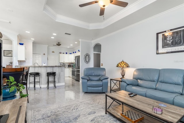 16450 Bauers Ave, Port Charlotte, FL 33954 - living room featuring arched walkways, ornamental molding, a ceiling fan, a tray ceiling, and recessed lighting