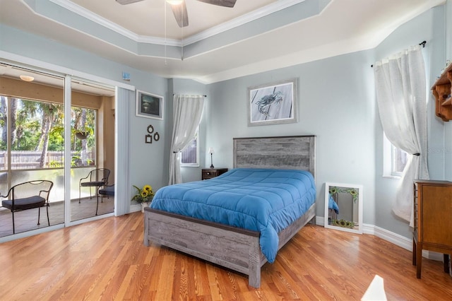 16450 Bauers Ave, Port Charlotte, FL 33954 - bedroom with multiple windows, access to outside, a tray ceiling, and wood finished floors