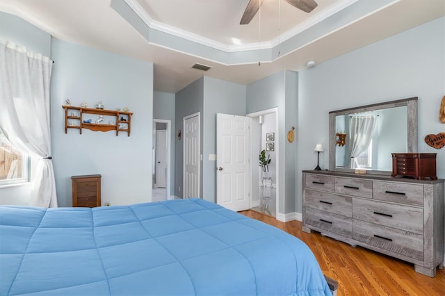 16450 Bauers Ave, Port Charlotte, FL 33954 - bedroom with ornamental molding, visible vents, wood finished floors, a raised ceiling, and ceiling fan