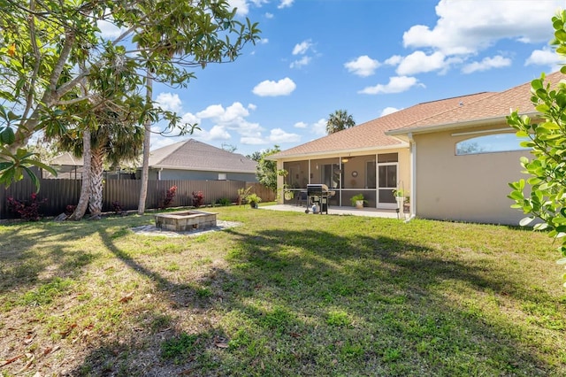 16450 Bauers Ave, Port Charlotte, FL 33954 - view of yard featuring a sunroom, a fenced backyard, and an outdoor fire pit