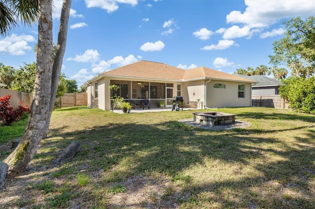 16450 Bauers Ave, Port Charlotte, FL 33954 - back of property with a fenced backyard, a sunroom, a lawn, and stucco siding