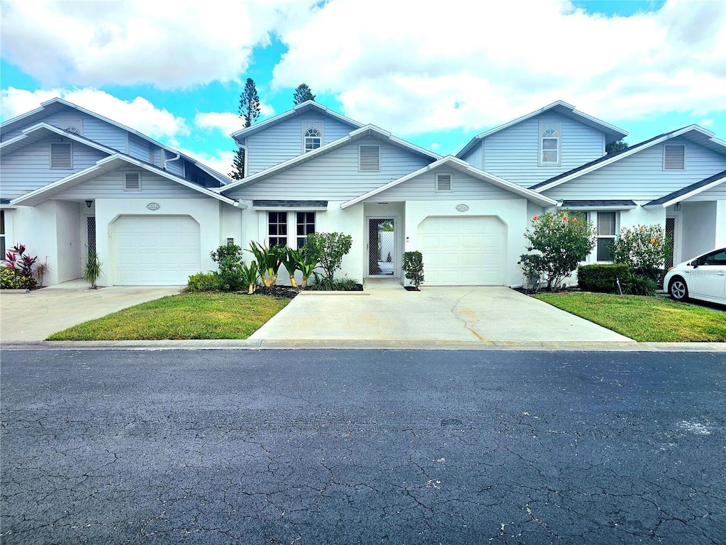 13665 Abbey Dr Unit 2, Fort Myers, FL 33919 - view of front facade with driveway, a garage, and stucco siding