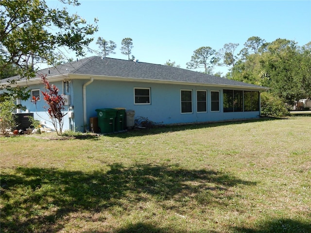 1233 Dewhurst St, Port Charlotte, FL 33952 - back of property with a yard, central air condition unit, a sunroom, and stucco siding