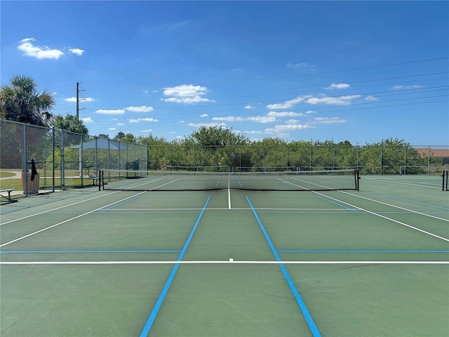view of tennis court with community basketball court and fence